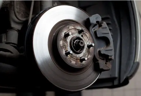 Car brake rotor and caliper during brake repair in Charlotte, NC.