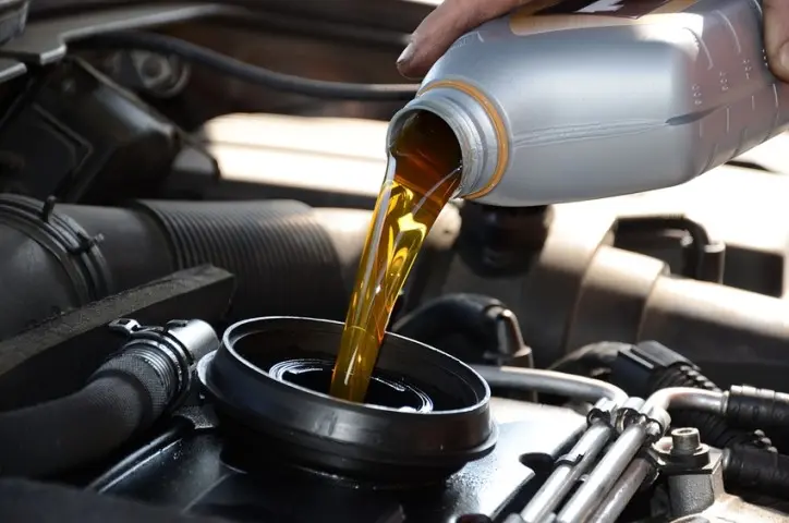 Engine oil being poured into a car engine.