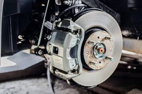 Vehicle brake disc and caliper during professional brake repair in Charlotte, NC.