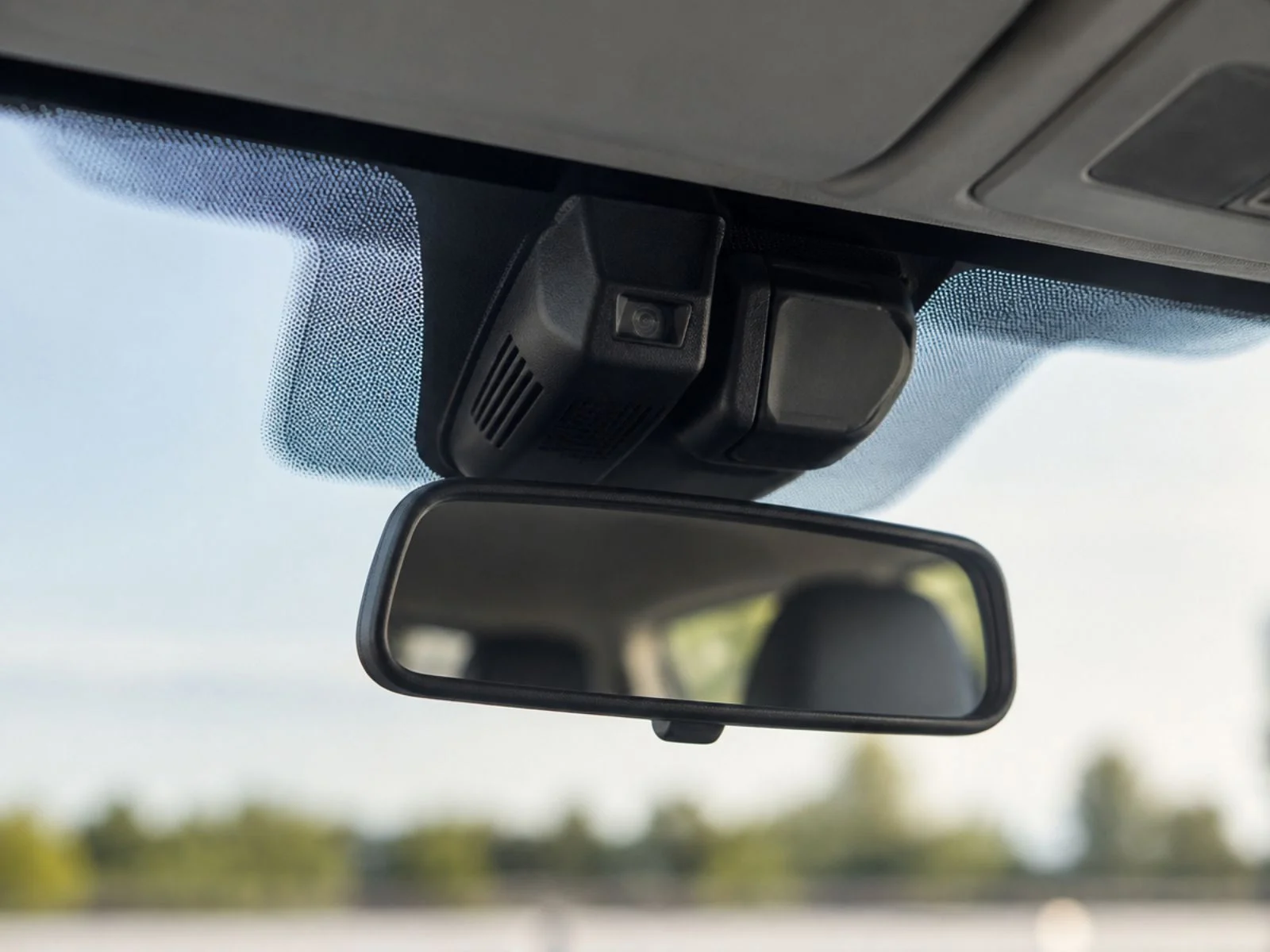 Windshield camera housing mounted above rearview mirror during service in Charlotte Forward facing camera housing mounted on a windshield above the rearview mirror